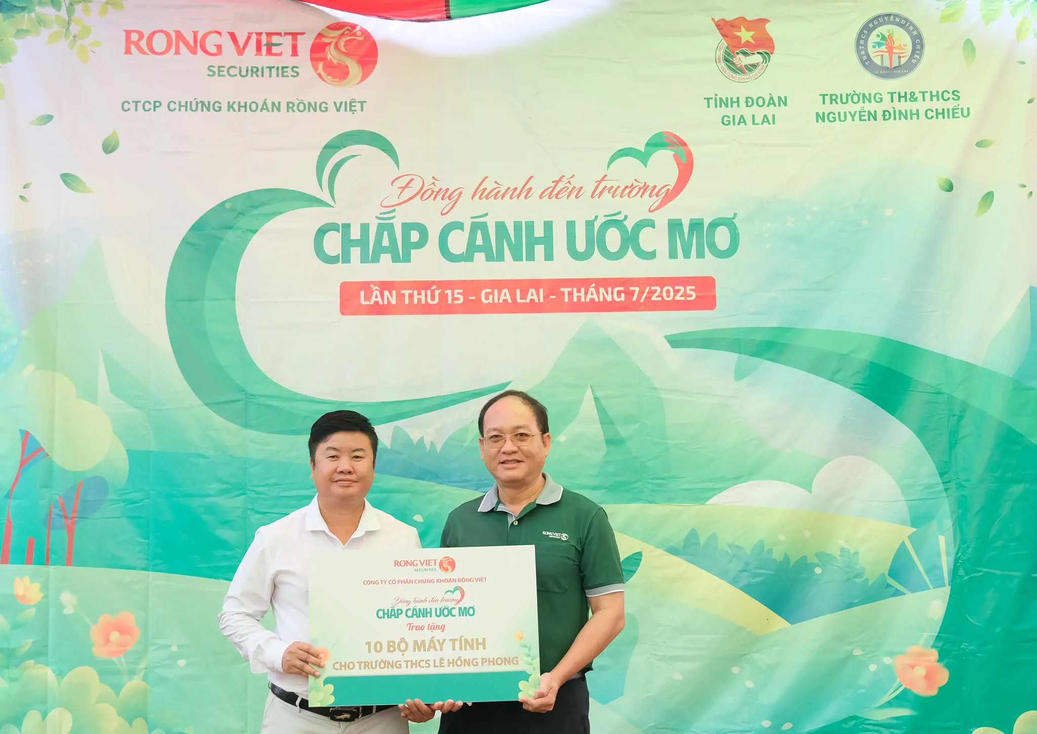 Thầy Nguyễn Văn Mỵ - Hiệu trưởng trường THCS Lê Hồng Phong (bên trái) đại diện nhận 10 bộ máy tính từ Rồng Việt 